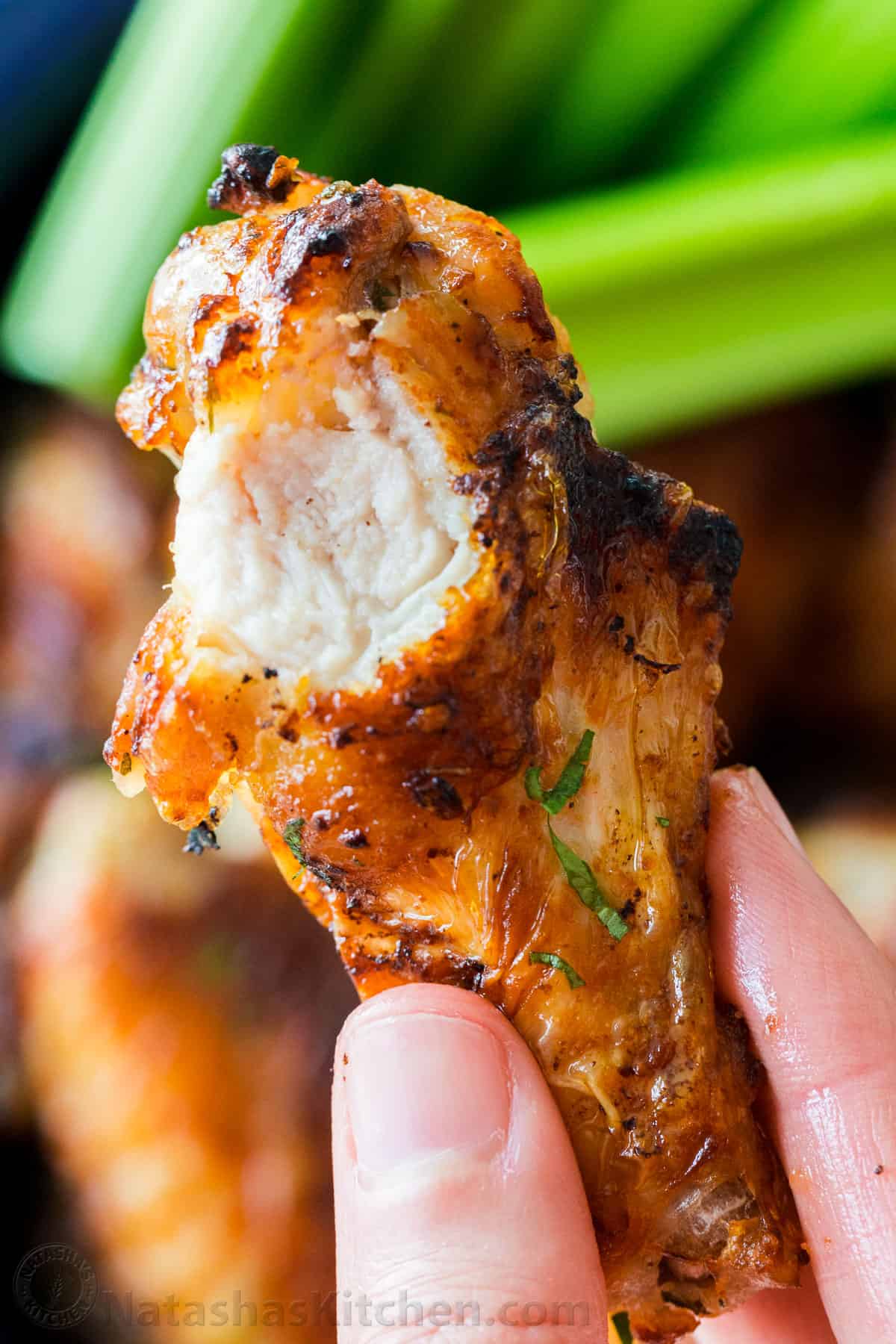 Air Fryer Chicken Wings with crisp salty skin, perfectly seasoned with garlic and lemon pepper. Air fried chicken wings cook so fast with no marinating! #airfryer #airfryerchicken #airfryerchickenwings #chickenwings #crispchickenwings #chicken #airfryerrecipes #natashaskitchen Bitten into Air Fryer chicken wing up close