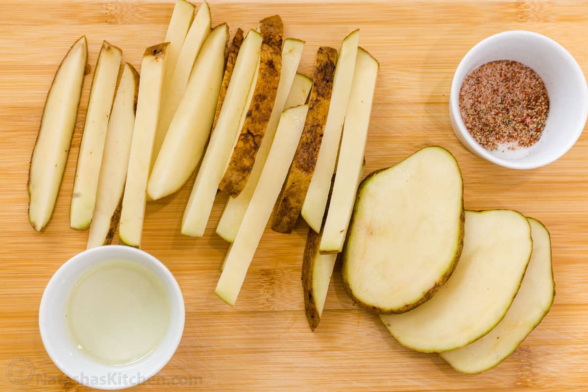 Learn how to make the BEST air fryer crispy and crunchy French fries that are seasoned and cooked to perfection. Sliced russet potatoes with seasonings and oil in bowls