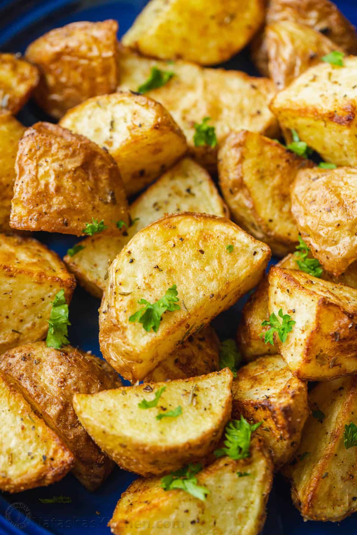Close up of air fryer roasted potatoes garnished with parsley.