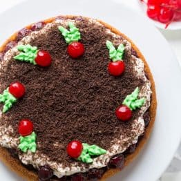 This Cherry Christmas Cake is simple, beautiful and tastes like Christmas! Sponge cake covered with 1 lb cherries and whipped frosting. Easy Cherry Cake! | natashaskitchen.com