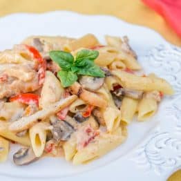 A plate of chicken and vegetable penne alfredo
