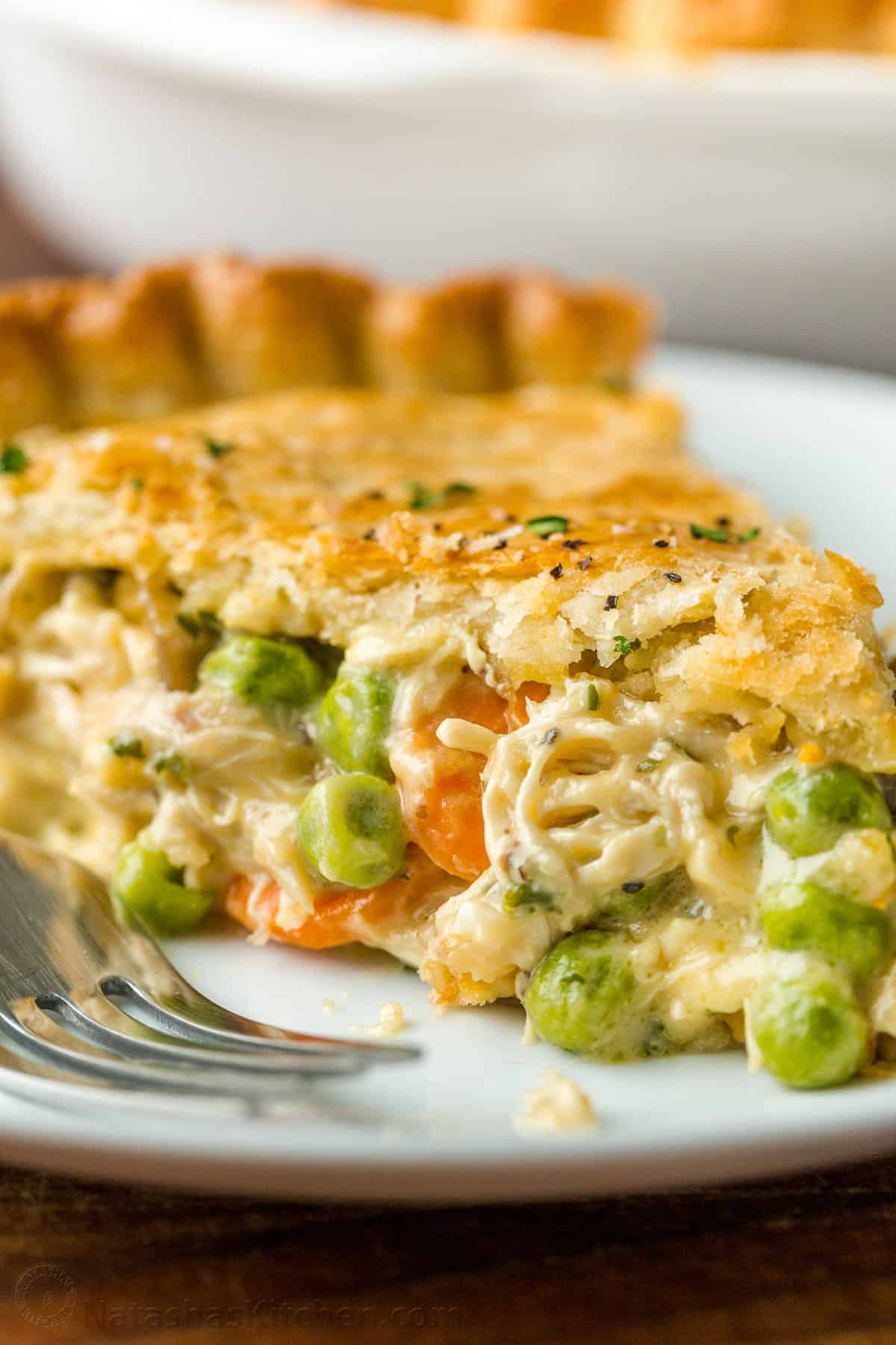 Chicken Pot Pie Recipe with a flaky crust, filled with juicy chicken and veggies in gravy. Homemade Chicken Pot Pie is a classic comfort food. Chicken pot pie, filled with chicken and vegetables, sliced and served on a plate with fork