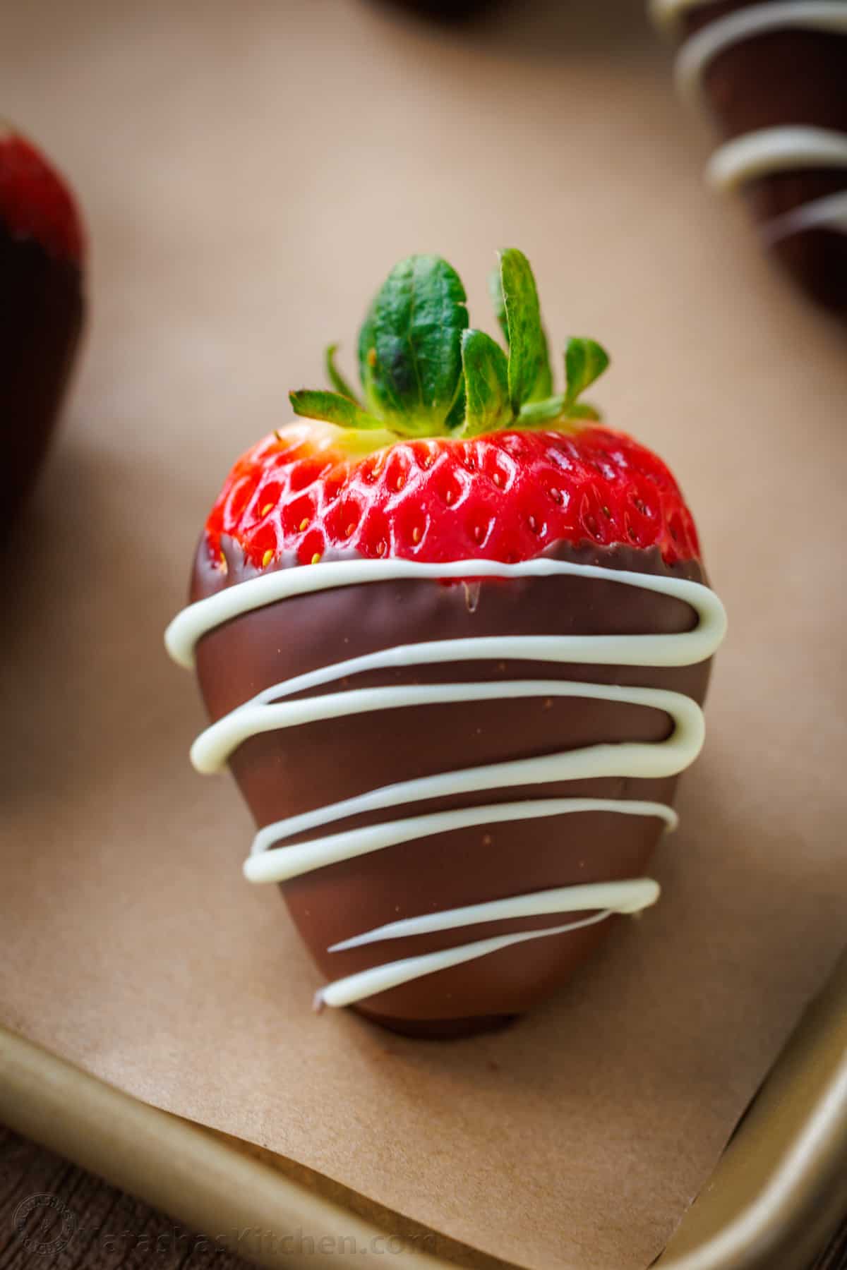 How to make the BEST Chocolate Covered Strawberries. Everything you need to know for melting chocolate, dipping, and decorating strawberries. single close up of chocolate covered strawberry drizzled with chocolate