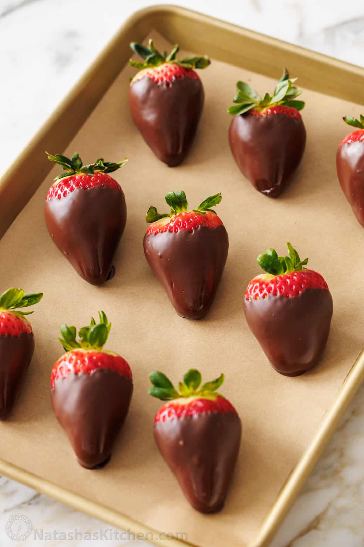 How to make the BEST Chocolate Covered Strawberries. Everything you need to know for melting chocolate, dipping, and decorating strawberries. easy chocolate covered strawberries arranged on parchment paper