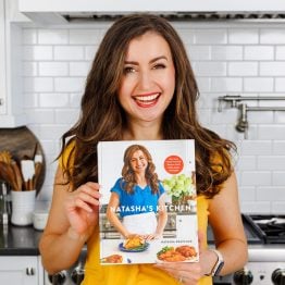 Natasha Kravchuk author holding Natasha's Kitchen Cookbook