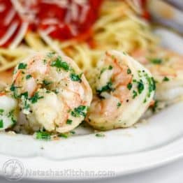 A close up of garlic and herb shrimp on a plate