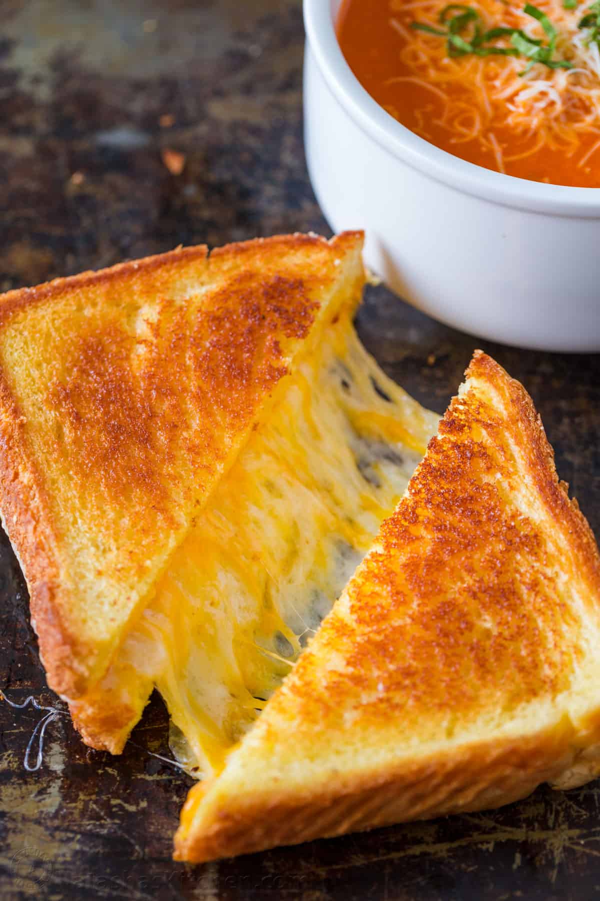 Learn how to make the best Grilled Cheese sandwich with a crisp, buttery exterior and gooey cheese center. Make grilled cheese like a pro! Grilled cheese sandwich served with tomato soup