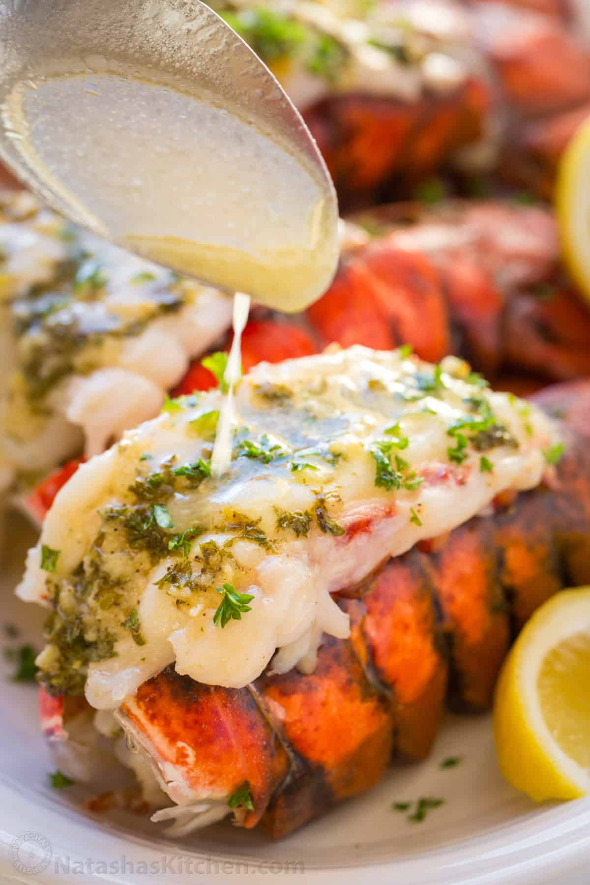 This Lobster Tail recipe with garlic butter sauce is juicy, flavorful, and easy. Includes an easy tutorial on how to butterfly lobster tail. Pouring butter sauce over broiled lobster tail