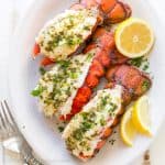 Lobster tails on a serving platter with lemon wedges