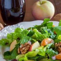 A plate of mandarin apple salad with a whole apple behind it
