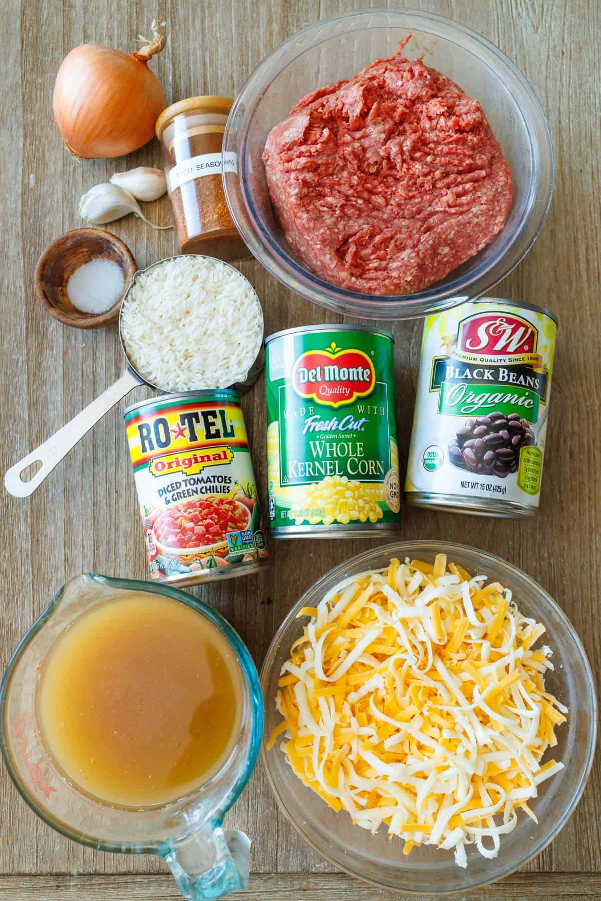 Ingredients for Mexican Beef and Rice Skillet: Ground beef, jasmin rice, chicken stock, garlic, salt, shredded cheese, black beans, onion, corn, Rotel tomatoes, taco seasoning