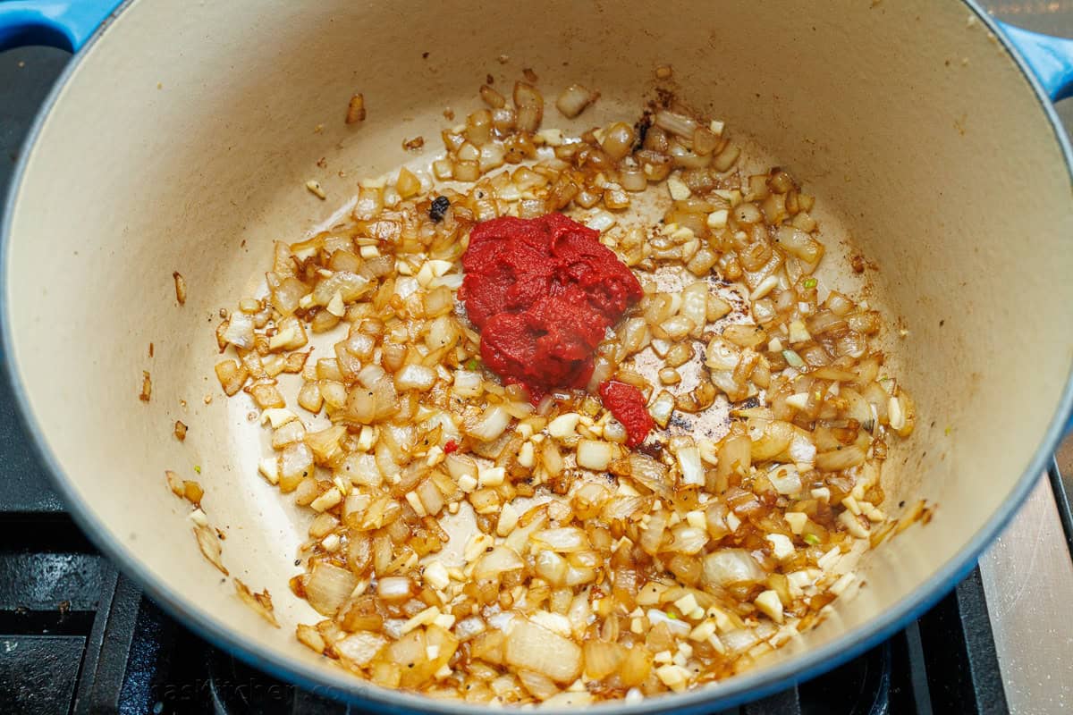 This is the best Pot Roast Recipe to get amazingly tender beef with a savory and satisfying sauce. It will become your go-to comfort recipe! Onions and garlic in a dutch oven with tomato paste