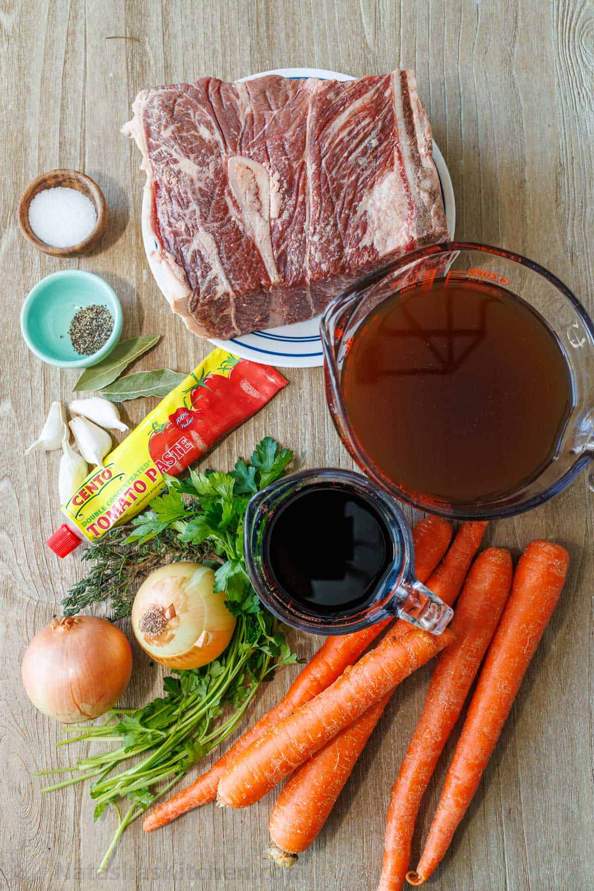 This is the best Pot Roast Recipe to get amazingly tender beef with a savory and satisfying sauce. It will become your go-to comfort recipe! ingredients for cooking beef in the oven including chuck shoulder steak, salt, pepper, garlic, bay leaves, tomato paste, onion, parsley, thyme, carrots, red wine and beef broth