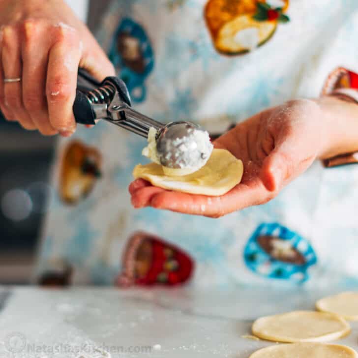Pierogi filled with cheesy potatoes and served with crisp bacon, melted butter and sour cream. Homemade Pierogi is the ultimate comfort food! Using a small scoop to fill dumplings
