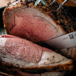 A garlic-crusted Prime Rib Recipe with a trusted method for juicy, melt-in-your-mouth tender prime rib roast. Watch the video tutorial and learn how to trim, tie, wrestle (kidding), and cook prime rib.