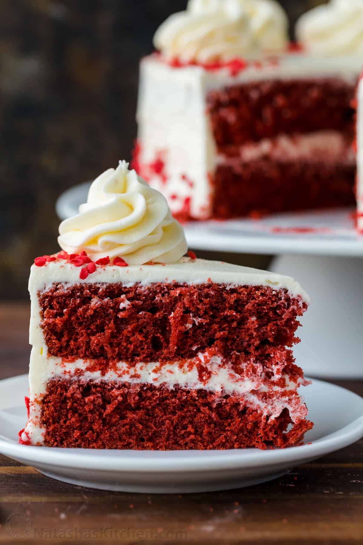 Our homemade Red Velvet Cake has a soft and moist crumb with the best Cream Cheese Frosting. Perfect for Valentine's, birthdays, or any special occasion. Slice of red velvet cake on a plate