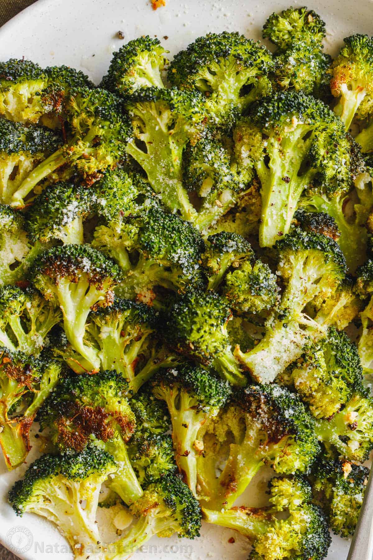 Roasted Broccoli on a plate garnished with parmesan cheese
