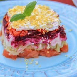 A piece of shuba with salmon on a white plate