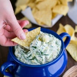 This skinny spinach and artichoke dip uses Greek yogurt. Serve it warm and cheesy. It's perfect for game day or any occasion.