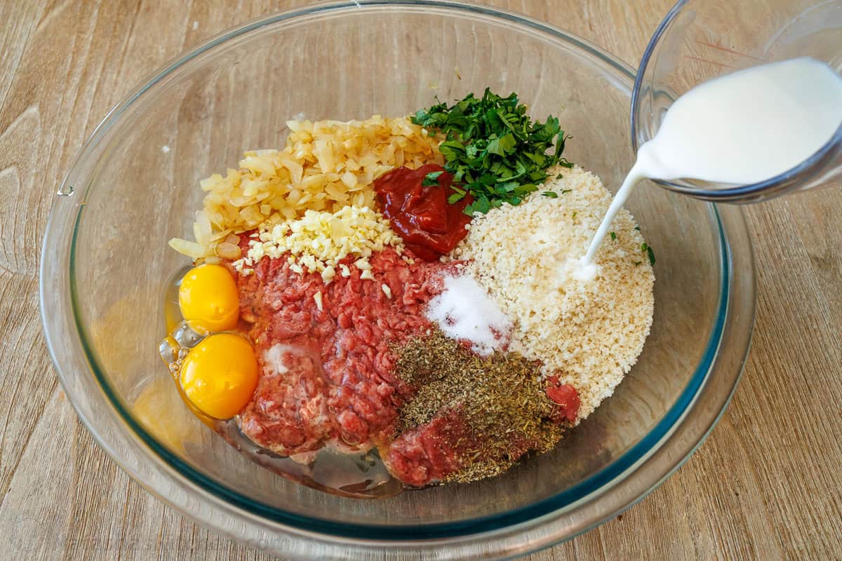 Classic Meatloaf Recipe topped with an amazing sauce. The meatloaf is so juicy and flavorful. Comfort food with a 10-minute prep time. Meatloaf ingredients combined in a mixing bowl