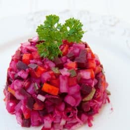 Russian vinaigrette salad with beets and sauerkraut on a white plate