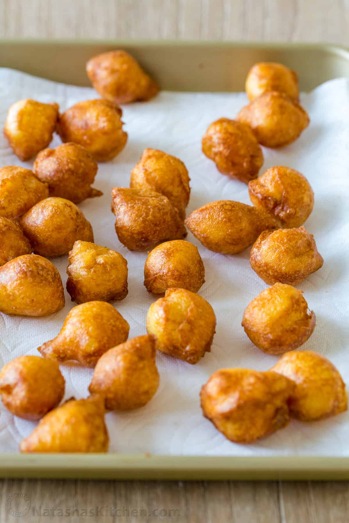 Zeppole donuts are rolled in sugar with a fluffy, melt-in-your-mouth center. These Italian donut holes are simple to make and always disappear fast. Donuts draining on paper towel lined tray